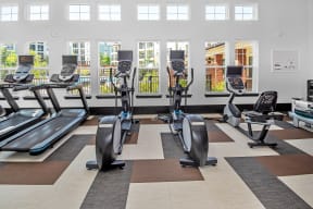 a gym with treadmills and elliptical machines on a checkered floor