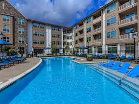 A large swimming pool in front of apartment buildings.