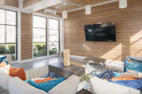 A living room with a flat screen TV mounted on the wall.