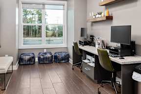 a home office with desks and chairs and a window
