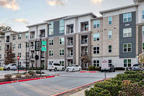 an apartment building with cars parked in front of it