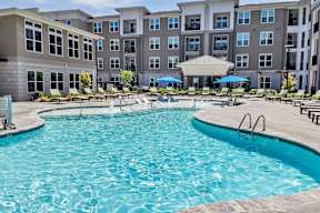 a swimming pool with an apartment building in the background