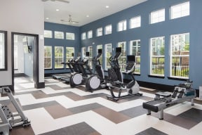 a gym with a lot of machines and windows