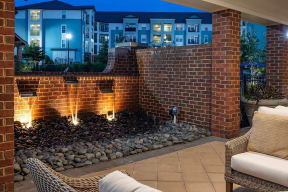 a fire pit in front of a brick wall