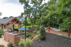 a backyard with a hammock and a pavilion and trees