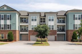 an exterior view of an apartment building with a driveway