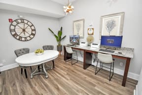 a business center with a table and chairs and a desk with computers
