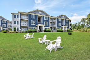 a large lawn with chairs and a building in the background