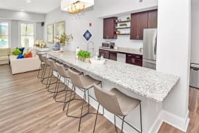 a clubhouse kitchen with a large island with a breakfast bar