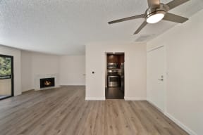 an empty living room with a fireplace and a ceiling fan at Croft Plaza Apartments, California, 90069