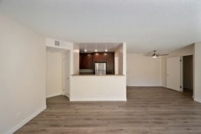 an empty living room with a kitchen in the background at Croft Plaza Apartments, West Hollywood California