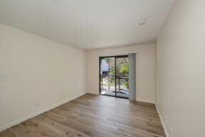 a bedroom with hardwood floors and white walls at Croft Plaza Apartments, West Hollywood California