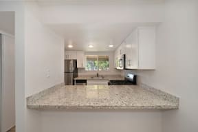 a kitchen with granite countertops and white cabinets