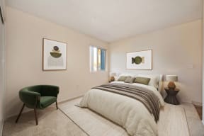 Bedroom In 2x1 Floor Plan  with queen sized bed with dark green accent chair.  Room has light carpeting and beige painted walls.