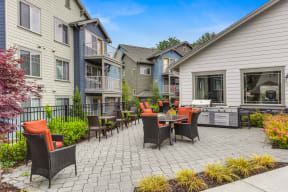 Outdoor Seating Area with Grill, Orange Chairs, Tile Inspired Floor, Blue Apartment Exterior