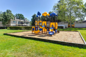 Playground with Sand, Grass and Apartment Exteriors at Hidden Oaks Apartments, Citrus Heights, CA, 95621