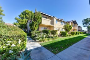 Community Property Grounds with Open Grass, Concrete Sidewalks, and Gated Apartment Structures