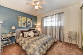 Olympus Park model home bedroom with carpet, window and ceiling fan.
