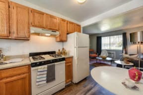 Kitchen with View of Living Room,  Hardwood Inspired Floors, Oven and Wood Cabinets at Olympus Park Apartments, Roseville, 95661