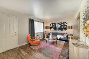 Living Room with Hardwood Inspired Floors, Orange Chairs and Window  at Olympus Park Apartments, Roseville, CA, 95661