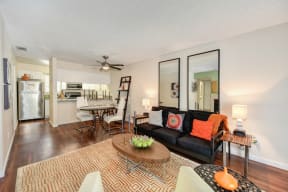 Living Room with Hardwood Inspired Floors, Black Sofa and Mirrors at Hidden Oaks Apartments, California, 95610