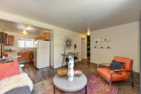 Living Room with Hardwood Inspired Floors, Orange Chairs and Table at Olympus Park Apartments, Roseville, 95661
