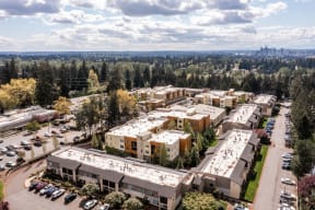 Drone ariel shot of the apartment community and the city in the distance.