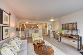 Model Living Room with View of Kitchen, White Sofa, Hardwood Inspired Floor, Lime Chairs, Ornamental Animal and Green Vase on Wood Table