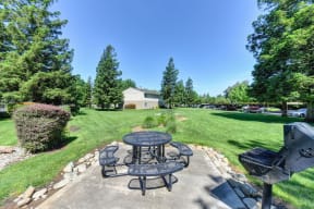 Community BBQ and Picnic Area with Black Table on concrete pad. at Monte Bello Apartments, Sacramento, CA, 95826