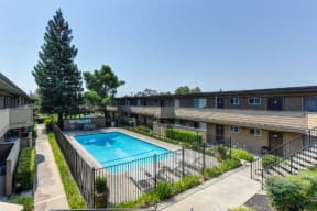 Outdoor Swimming Pool and Lounge Area, Trees, Bushes and Apartment Exteriors  at Olympus Park Apartments, California, 95661