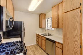 Classic, non-renovated apartment home with older wood colored cabinets in the kitchen