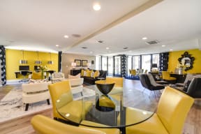Community leasing office with bright yellow accent walls and yellow chairs around a round glass table
