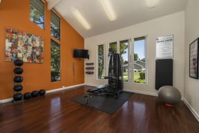 a home gym with hardwood floors and orange walls