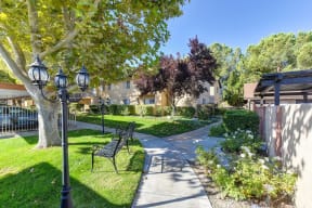 Property Grounds with Walking Paths, Streetlights, Park Benches, Trees, Plants, Grass and Apartment Exteriors