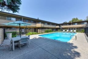 Swimming Pool and Lounge Area, Table and Sun Umbrella  at Olympus Park Apartments, Roseville, CA
