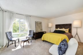 a bedroom with a large window and yellow bedspread at The Retreat at Walnut Creek, Walnut Creek, California