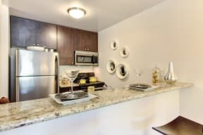 a kitchen with granite countertops and stainless steel appliances at The Retreat at Walnut Creek, Walnut Creek, California