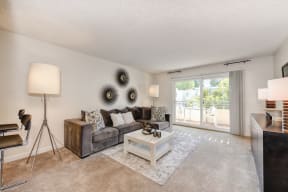 a living room with a couch coffee table and a sliding glass door at The Retreat at Walnut Creek, Walnut Creek