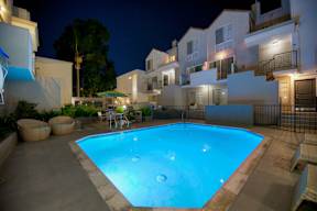 A swimming pool in a backyard at night.