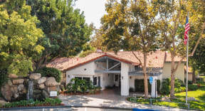 a building with a red tile roof and a pool in front of it