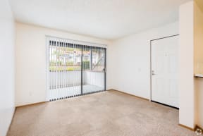 a bedroom with a large window and beige carpet