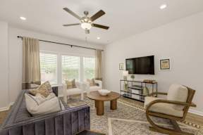 Living room with ceiling fan and modern furniture at The Courts at Maverick Yards Apartments, Mauldin, 29662