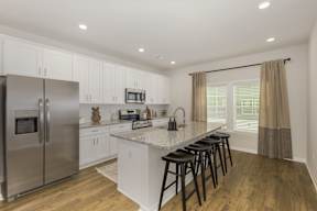 Modern kitchen with island seating and granite countertops at The Courts at Maverick Yards Apartments, South Carolina, 29662