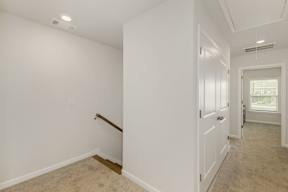 Upstairs hallway with carpeted flooring and staircase at The Courts at Maverick Yards Apartments, South Carolina, 29662
