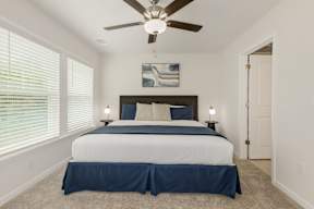 Bedroom with dark headboard and ceiling fan at The Courts at Maverick Yards Apartments, Mauldin, 29662