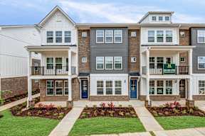 Multi story townhome exteriors with covered porches at The Courts at Maverick Yards Apartments, Mauldin, South Carolina
