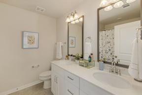 Bright bathroom with dual vanity and white cabinetry at The Courts at Maverick Yards Apartments, Mauldin