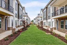 Courtyard with grassy lawn between residential buildings at The Courts at Maverick Yards Apartments, Mauldin, SC 29662