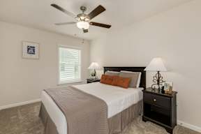 Guest bedroom with neutral decor and nightstands at The Courts at Maverick Yards Apartments, Mauldin, SC