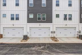 Three car garage doors with decorative hardware at The Courts at Maverick Yards Apartments, Mauldin, 29662